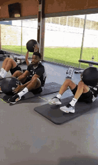 a group of people are doing exercises on mats in a gym .