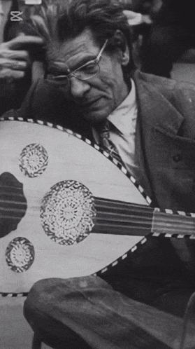 a black and white photo of a man playing a guitar with the letters bbc on the bottom