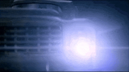 a close up of a car 's headlight with a blue light coming out of it .
