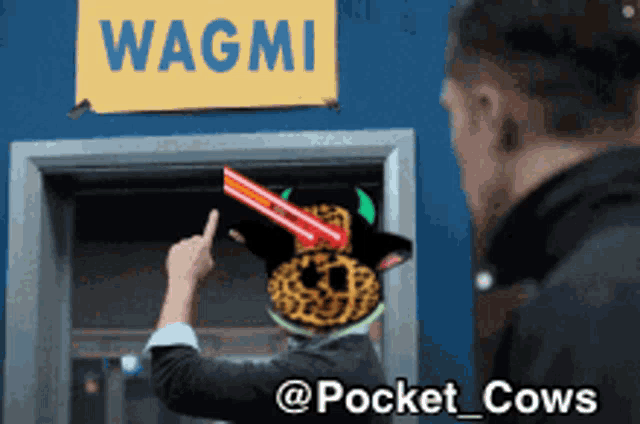 a man pointing at a sign that says wagmi on it
