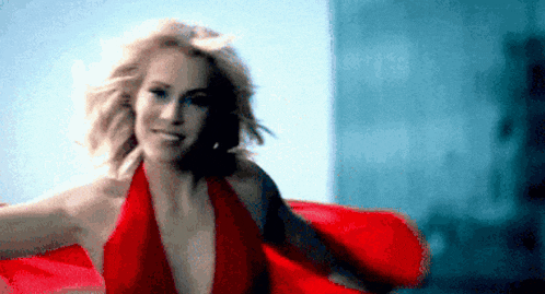 a woman in a red dress is dancing in a blurry photo