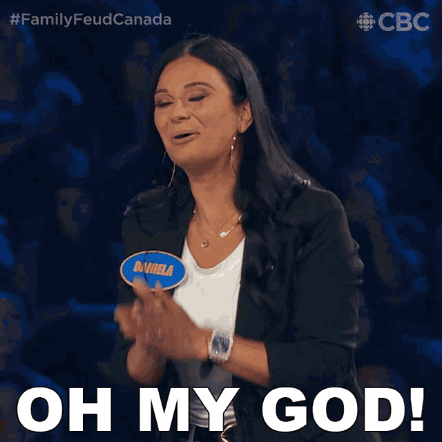 a woman applauds while wearing a name tag with daniela on it