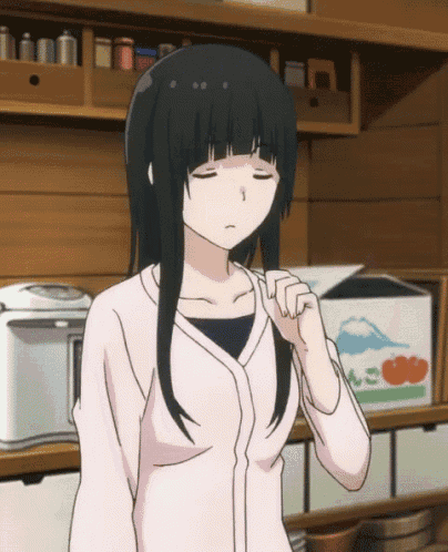 a girl with black hair and a pink shirt is standing in front of a box with tomatoes on it