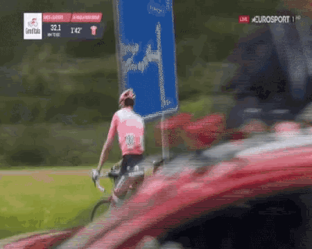 a man riding a bike in front of a sign that says ' eurosport ' on it
