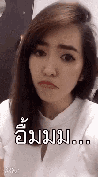 a woman in a white shirt is making a funny face with a foreign language on her face .