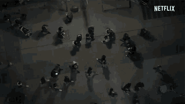 an aerial view of a group of people walking down a street at night .