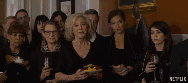 a group of people standing in a room with a netflix logo on the bottom right