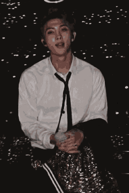 a man in a white shirt and black tie is dancing