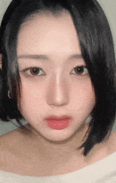 a close up of a woman 's face with a white sweater on