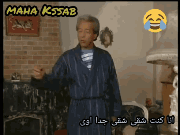 a man in a robe is standing in front of a brick wall with a sign that says maha kssab