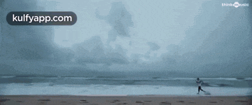 an aerial view of a person riding a wave on a beach