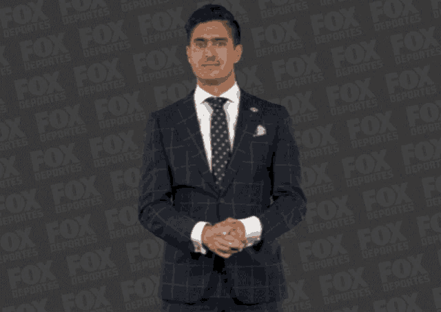 a man in a suit and tie is standing in front of a fox logo