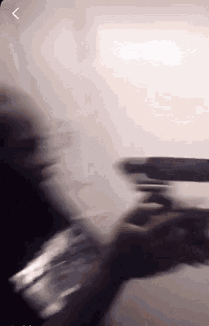 a blurry picture of a person holding a gun in their hand