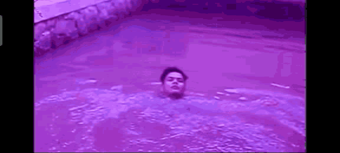 a man is swimming in a purple pool