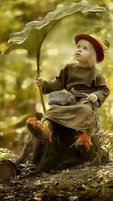 a little girl is sitting on a tree stump holding a leaf and a hedgehog .