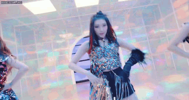a group of girls are dancing in a room with blue lights