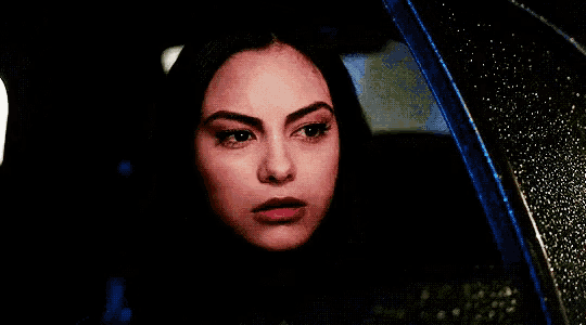 a close up of a woman looking out of a car window .