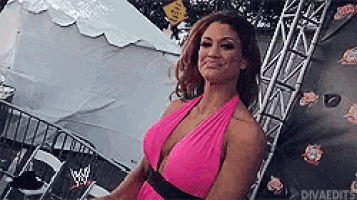 a woman in a pink dress is standing next to a tent .