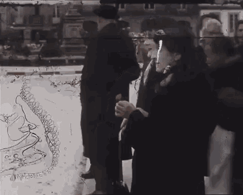 a woman in a black coat is holding an umbrella in front of a group of people