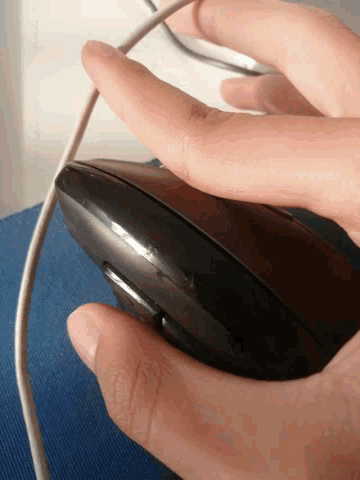 a person 's hand is holding a computer mouse