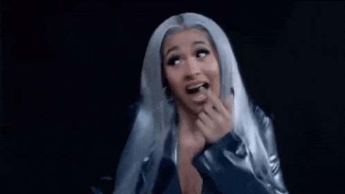 a woman with gray hair is smiling and making a funny face .