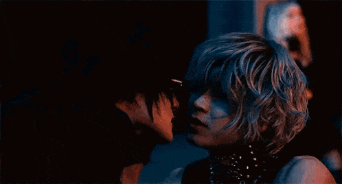 a man and a woman are kissing in the dark in a dark room .