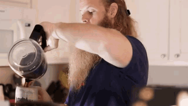 a man with a long beard pours coffee into a cup