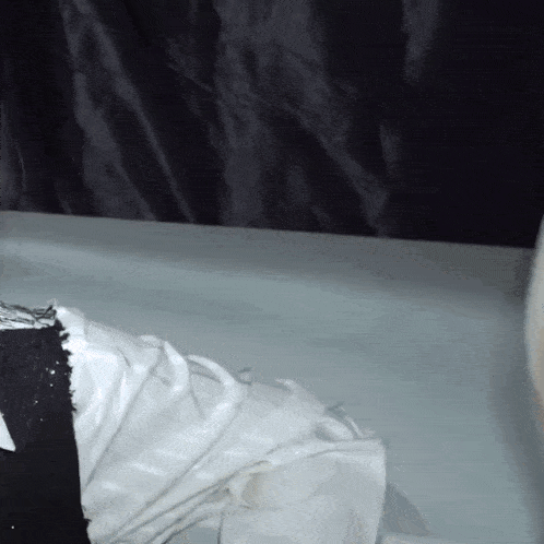 a person is laying in a bathtub with a white cloth on their feet .