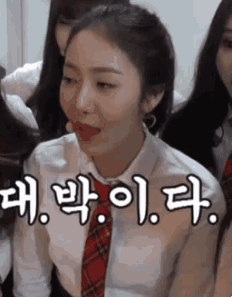 a woman wearing a white shirt and a red tie is making a funny face with her tongue out .