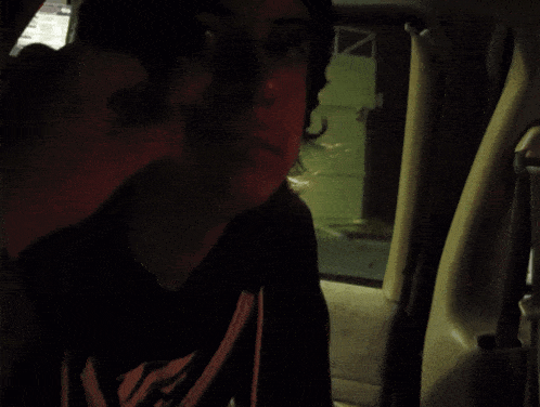 a blurry picture of a person holding a red object in a dark room