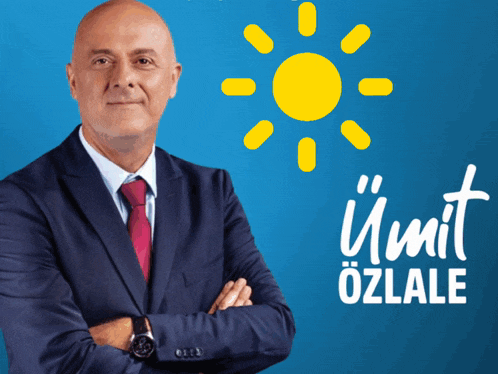 a man in a suit and tie stands with his arms crossed in front of a blue background with umit ozlala written in white