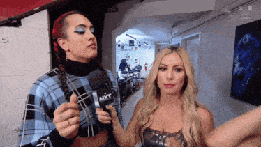 a woman holding a microphone that says nxt