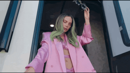 a woman with green hair and a pink jacket