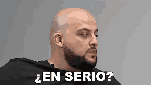 a bald man with a beard is sitting down and asking a question .
