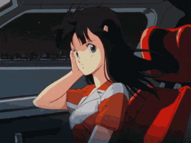 a girl with long black hair and green eyes is sitting in a car