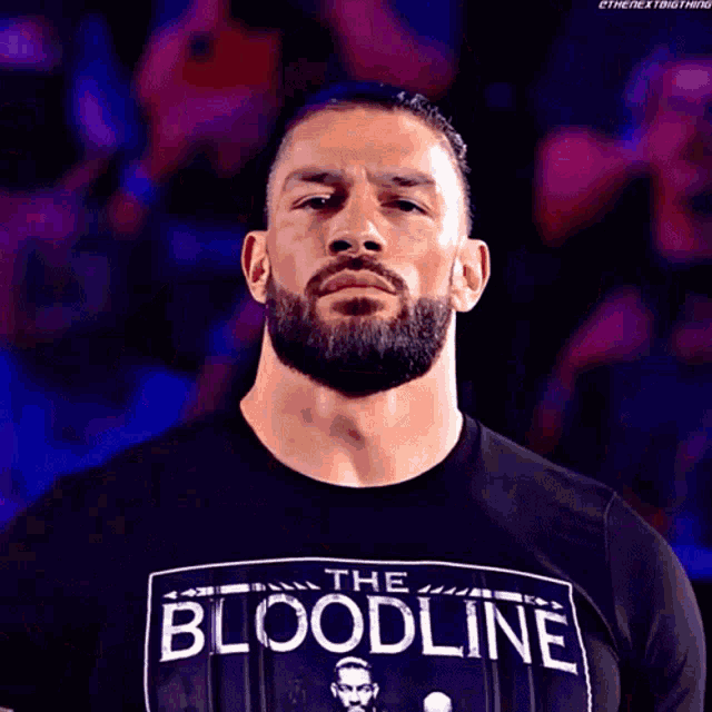 a man with a beard wearing a black shirt that says the bloodline