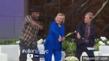 a woman in a blue suit is dancing with a man and a woman .