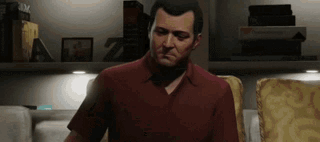 a man in a red shirt is sitting on a couch in a living room in a video game .