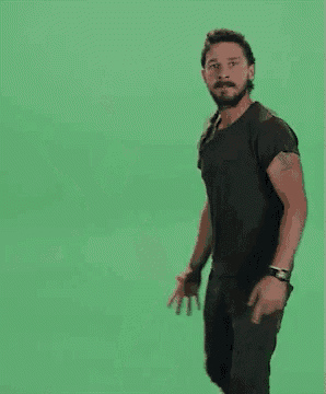 a man is dancing in front of a green screen with the words `` do it '' written on the screen .