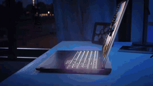 a laptop is sitting on a desk with the screen lit up at night