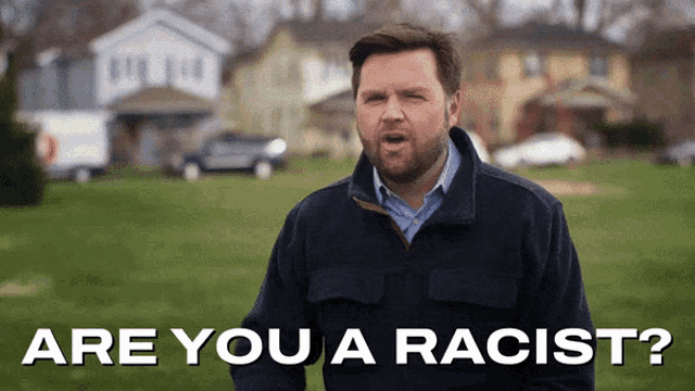 a man says are you a racist while standing in front of a house