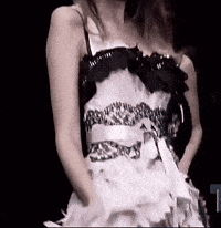 a woman in a white and black dress is dancing on a stage