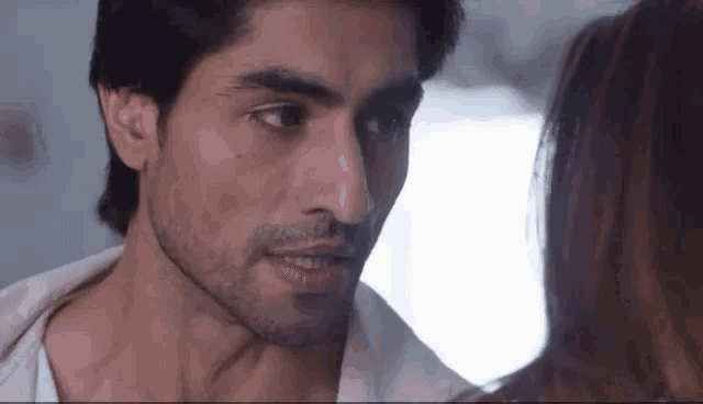 a close up of a man 's face looking at a woman