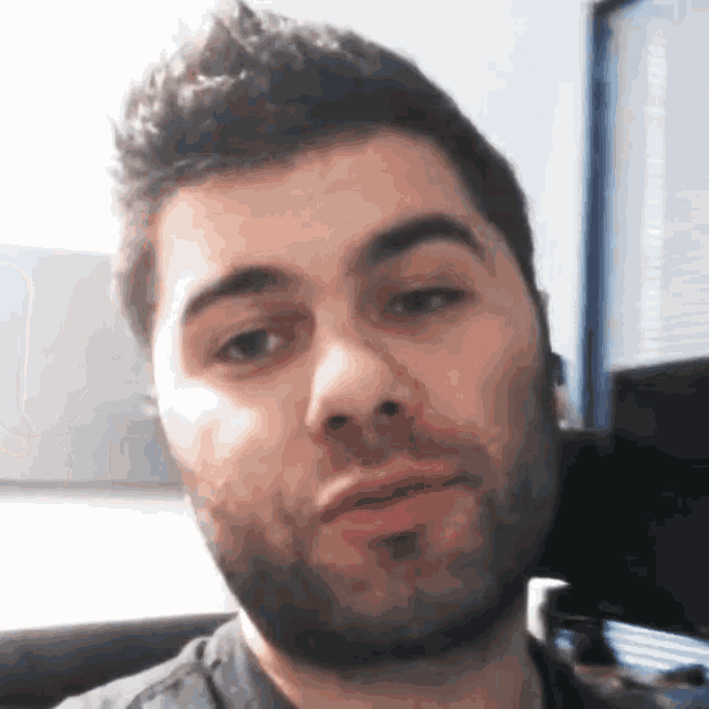 a man with a beard looks at the camera with his mouth open