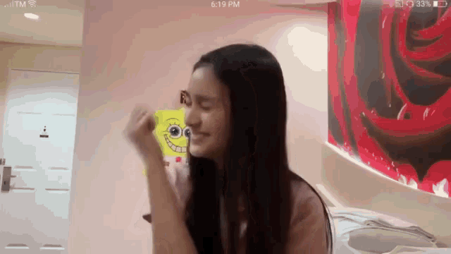 a woman in a room with a spongebob sticker on her wall