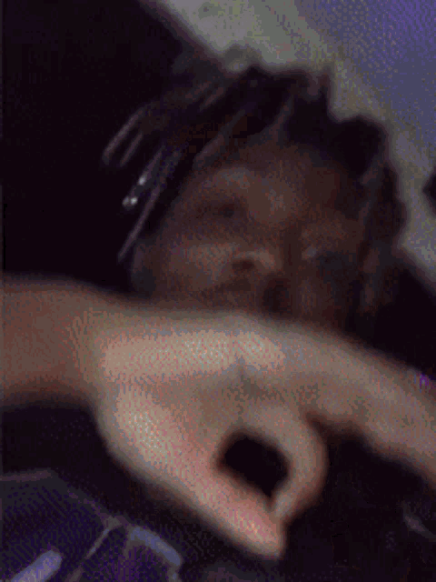 a blurry picture of a person making a peace sign with their hands
