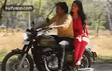 a man and a woman are riding a motorcycle together .