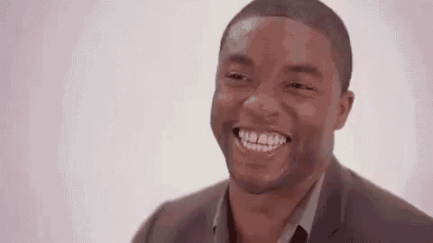 a man in a suit and tie is smiling and laughing .