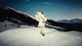 a man in a white fur coat is standing in the snow