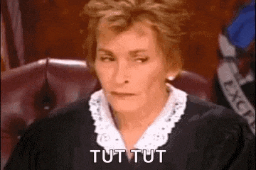 a female judge is sitting in a courtroom and saying tut tut .